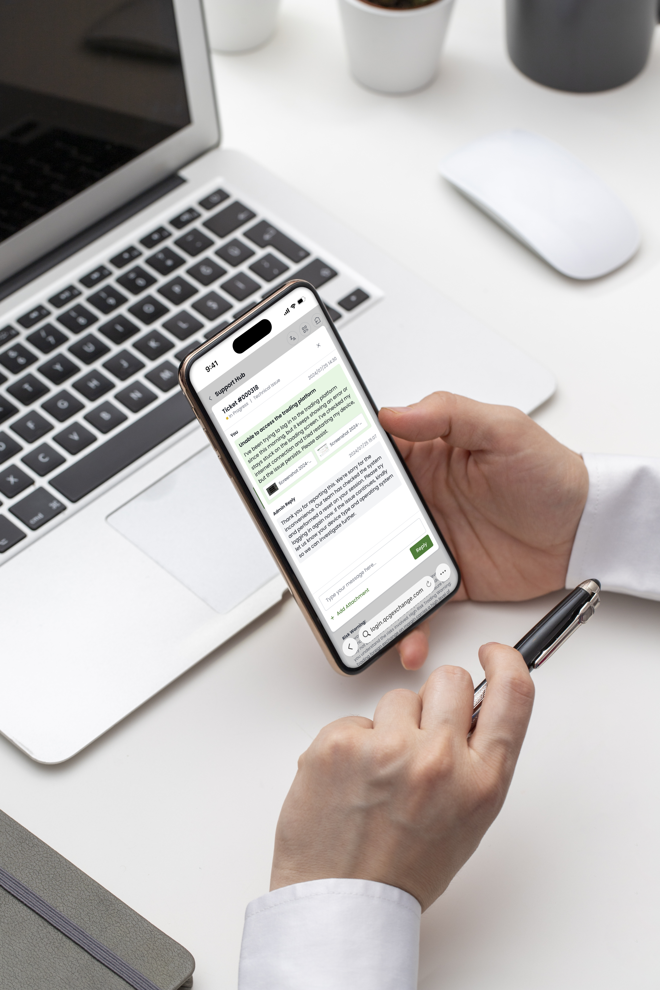 A person's hands holding a smartphone and a pen at a desk, with the phone displaying a 'Support Hub' chat interface regarding a technical issue with a trading platform.